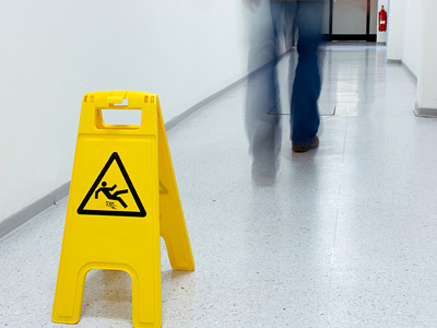 Warnschild für rutschige Böden in einem Flur.